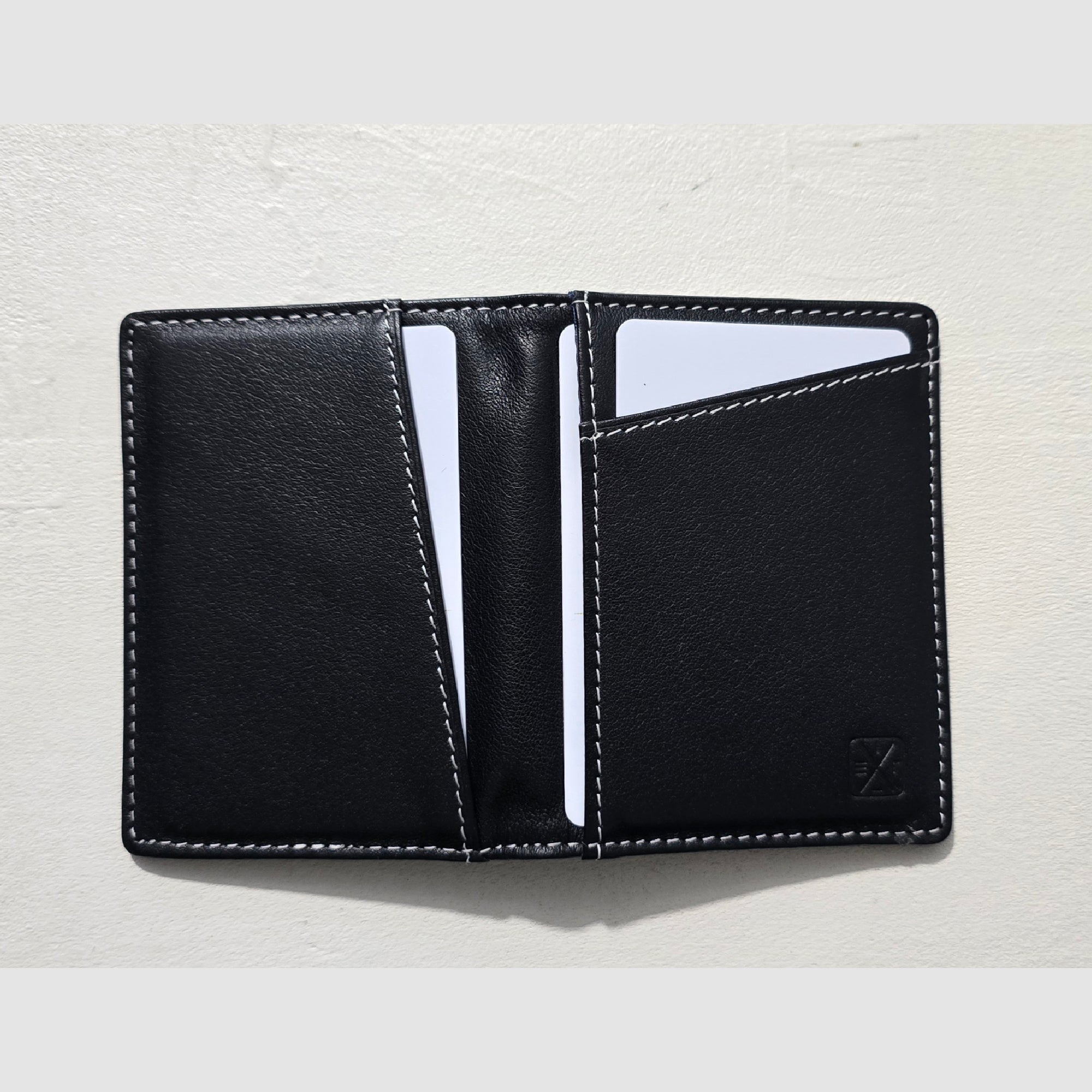 Black leather wallet with card slots on a light gray background