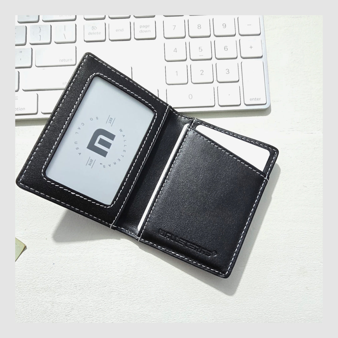 Black leather wallet with a brand logo on a white surface with a keyboard in the background