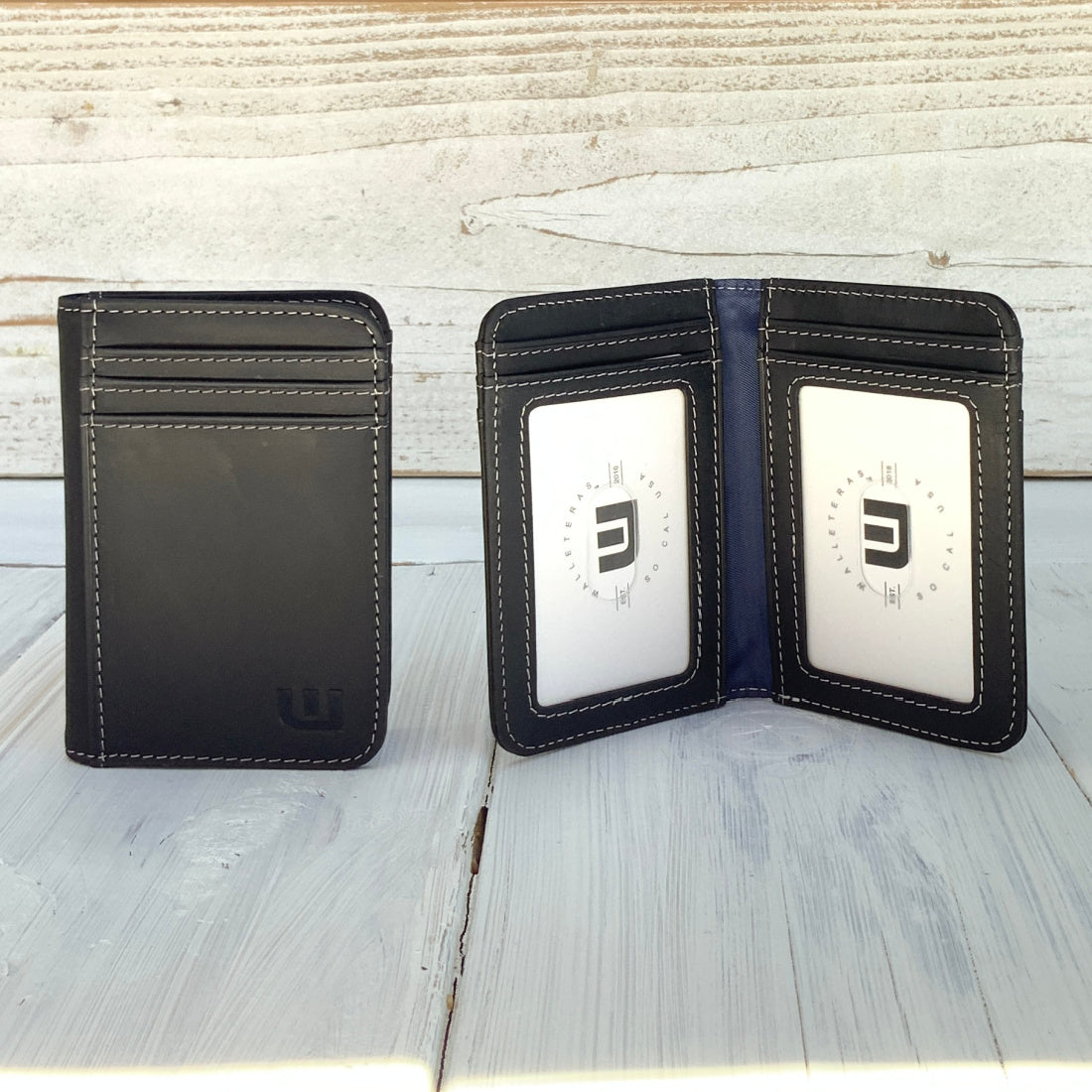 black leather wallet with two id windows on a table