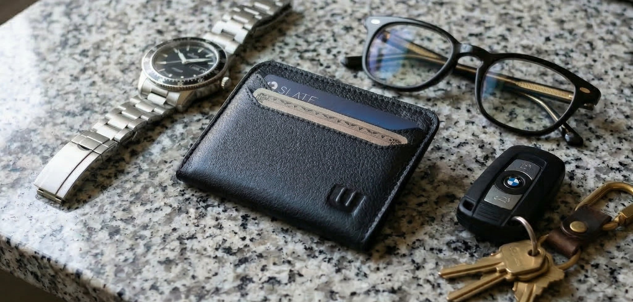 EDC Swag wallet next to 
watch and glasses and car keys on a granite counter